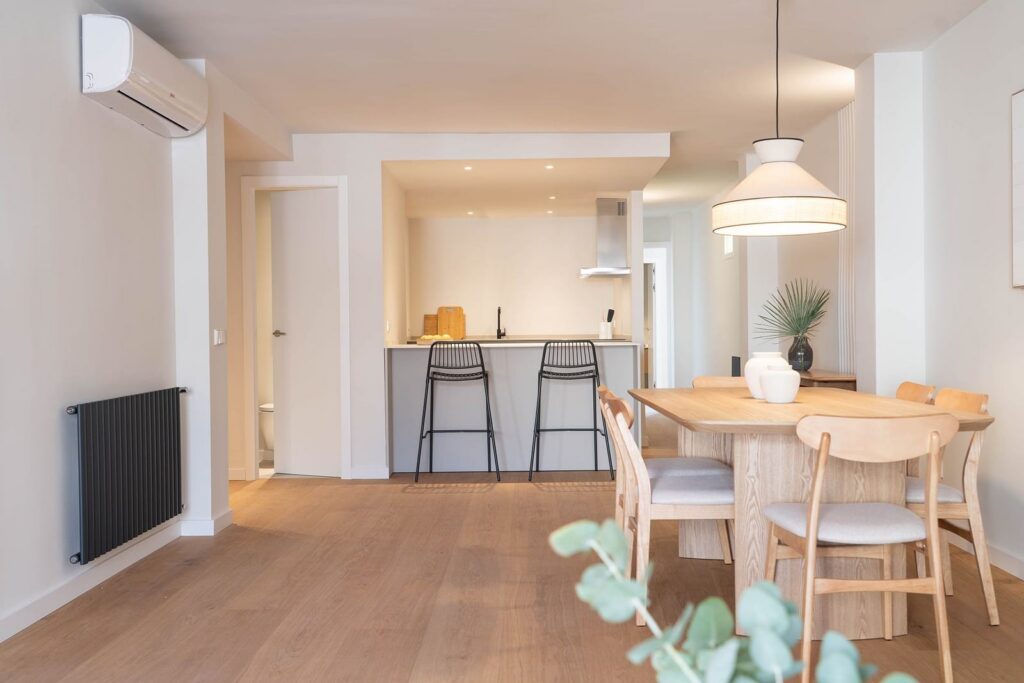 Zona de día con comedor de madera y cocina abierta