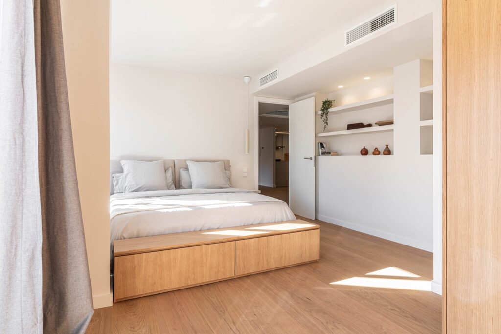 Dormitorio de MA2 con banco de madera y estanterías integradas
