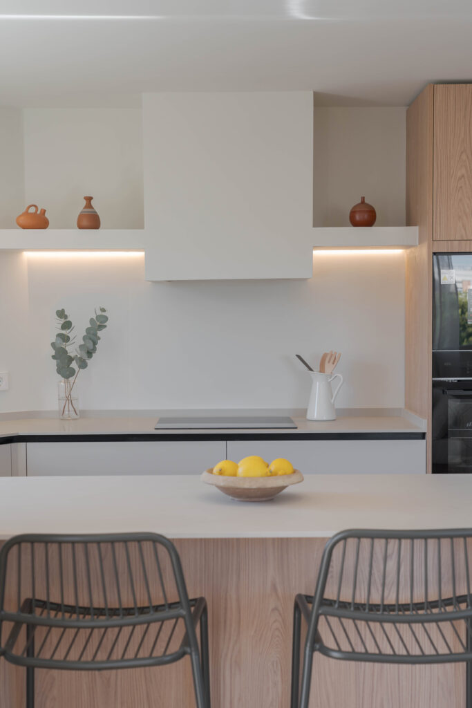 Detalle de la zona de cocción y la barra de la cocina con iluminación integrada