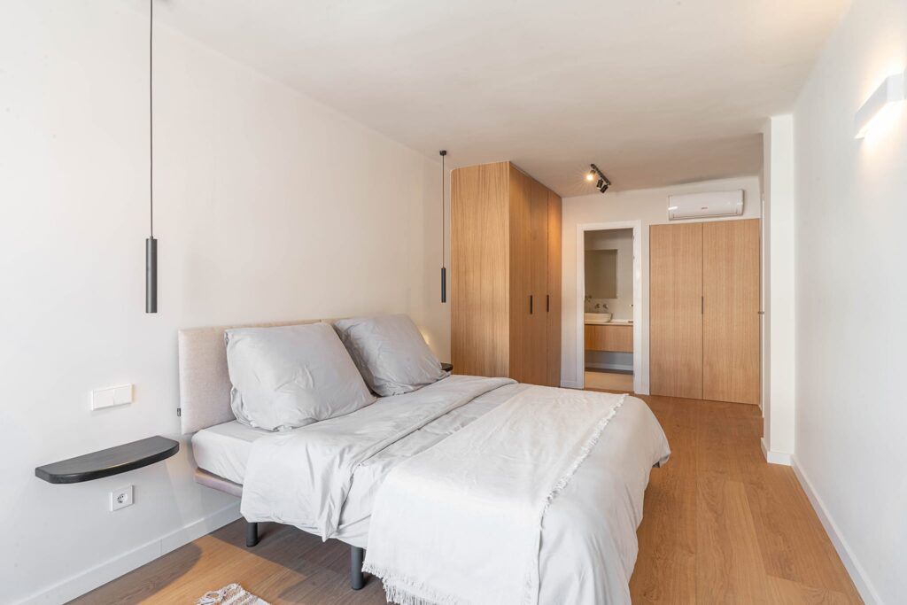Dormitorio con armarios de madera y acceso al baño