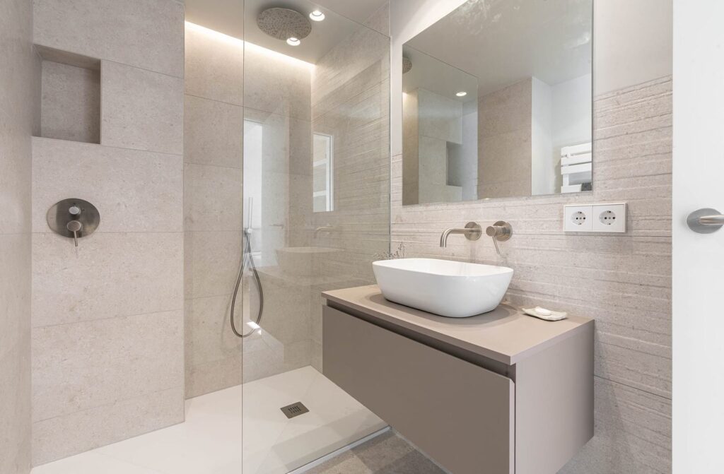 Baño con ducha, mampara y lavabo sobre mueble suspendido