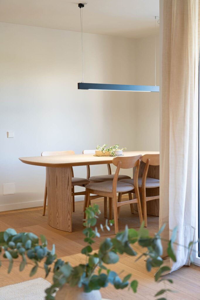 Comedor con mesa de madera junto al ventanal
