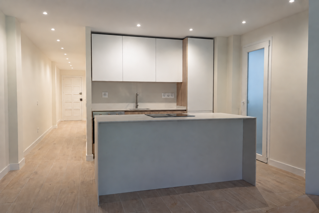 Cocina reformada con frentes blancos y acabado madera, vista desde la zona de día