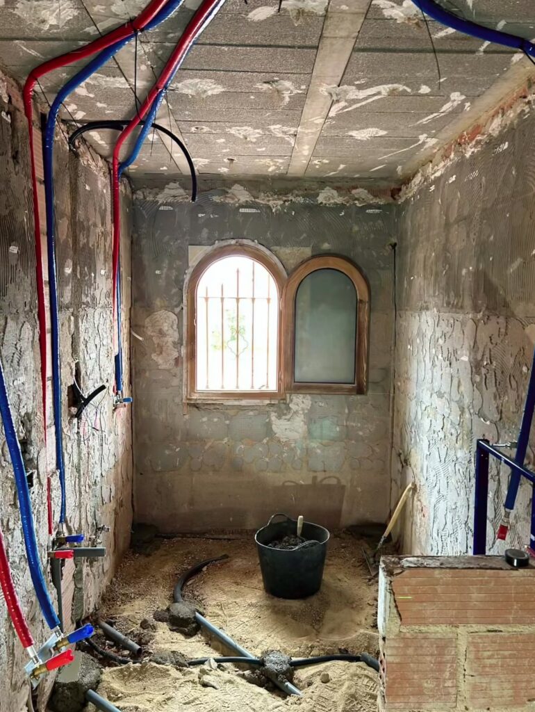 Bany de Verónica durant els treballs, amb instal·lacions vistes i finestra arquejada