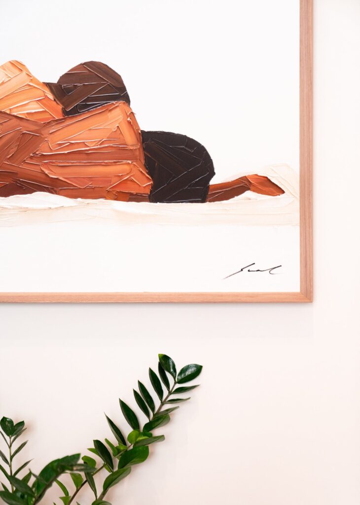 Detalle de obra de arte enmarcada sobre pared blanca