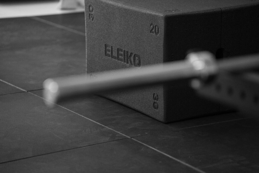 Detalle de cajón pliométrico y barra en la zona de gimnasio